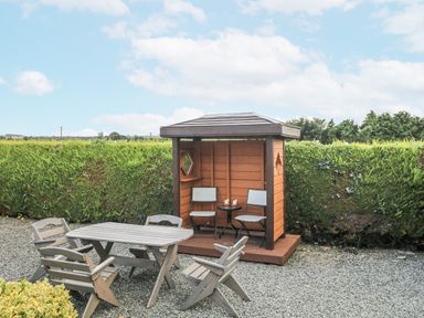 A garden shed with seating and a table at Dunbrody Dreams