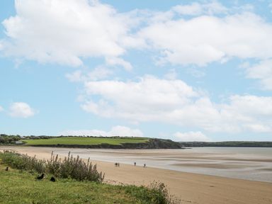 A beach scene with people walking on sand near water at Dunbrody Dreams