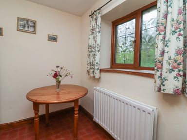 A dining room with a table and window at Denhill Cottage 