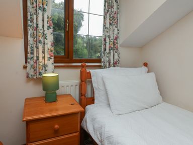 A bedroom with a bed and a nightstand at Denhill Cottage
