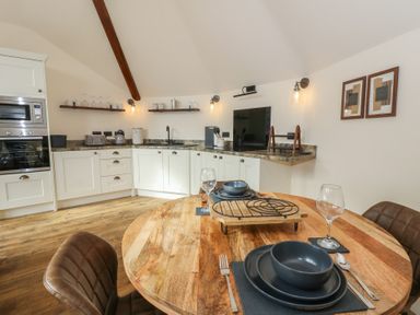 A kitchen with dining area and appliances at Yr Awen in Lampeter