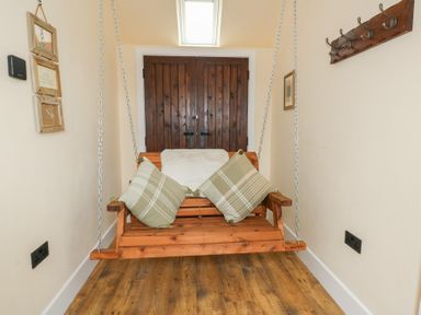 A swing with cushions in an indoor area at Yr Awen in Lampeter