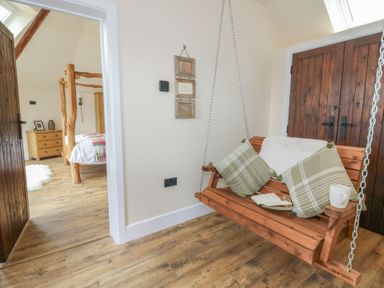 A swing seat and a doorway leading to a bedroom at Yr Awen in Lampeter