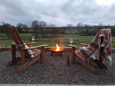 A seating area with chairs and a fire pit at Yr Awen - Inspiration Near Lampeter