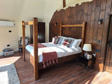 A bedroom with a wooden bed and nightstand at Y Cwlwm - The Celtic Knot near Lampeter