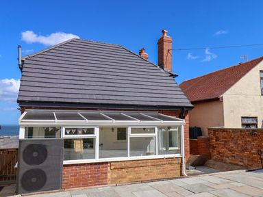 A conservatory with a brick wall and chimney at Floraville