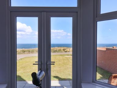 A view from a snug with a telescope overlooking the sea at Floraville