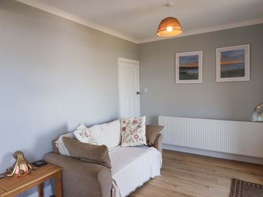 A living room with a sofa and wall art at Floraville