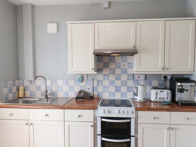 A kitchen with white cabinets and appliances at Floraville