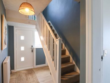 A hallway with a staircase and front door at Floraville