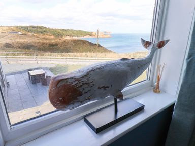 A whale sculpture by a window with an ocean view at Floraville