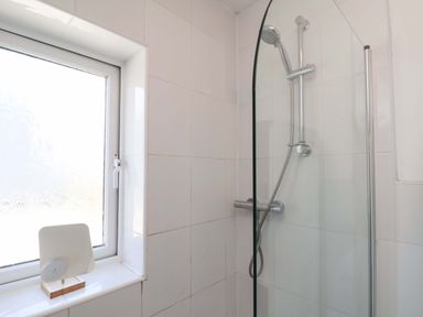 A shower area with a window and a wooden stand in Floraville