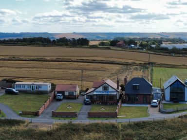 Houses and cars in a rural setting at Floraville in Cayton Bay