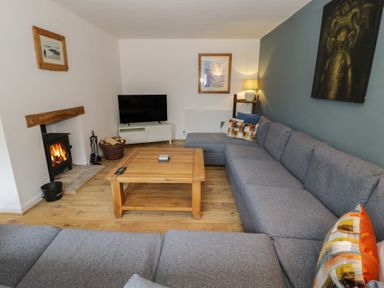 A living room with a tv and a fireplace at Harran in Pershore