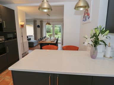 A kitchen with a dining area and a sofa at Harran in Pershore