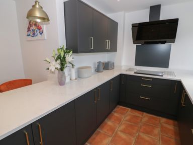 A kitchen with dark cabinets and a countertop at Harran in Pershore