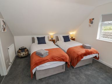 A bedroom with two beds and a window at Harran in Pershore