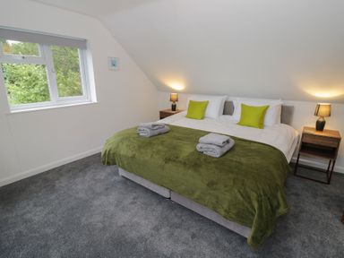 A bedroom with a bed and nightstands at Harran in Pershore