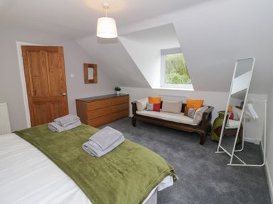 A bedroom with a bed and sofa at Harran in Pershore