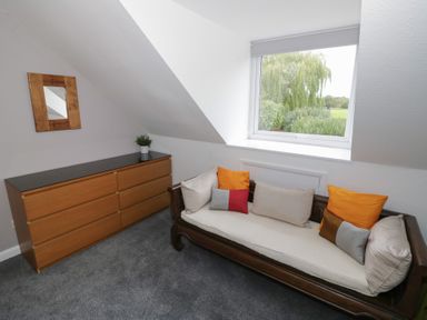 A bedroom with a sofa and dresser at Harran in Pershore