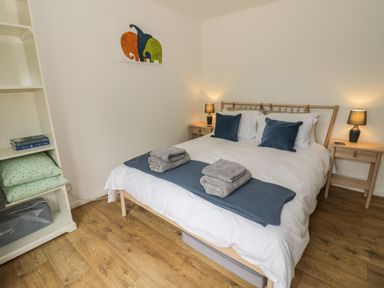 A bedroom with a bed and nightstands at Harran in Pershore