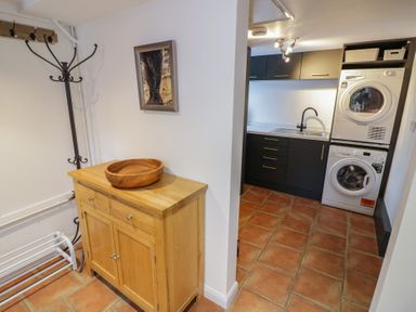 A laundry room with cabinet and appliances at Harran in Pershore