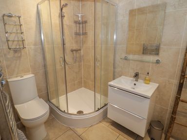 A bathroom with a shower, sink and toilet at Harran in Pershore