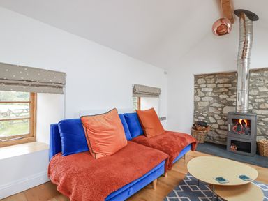 A living room with a blue sofa and a fireplace at The Old Dairy