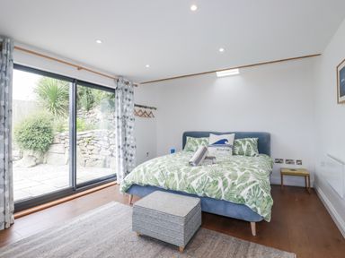 A bedroom with a bed, ottoman and window at The Old Dairy in 