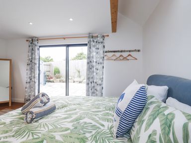A bedroom with a bed and patio doors at The Old Dairy in 