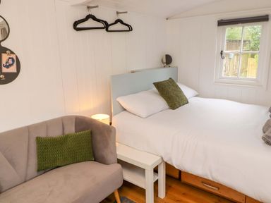 A bedroom with a bed and sofa at Shepherd's Hut Perranarworthal