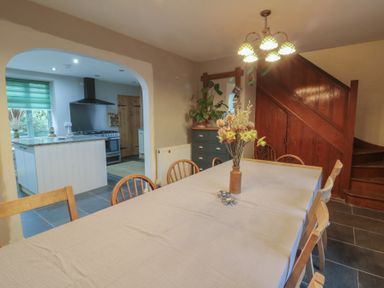 A dining room with a table and chairs at Penally Mews in St Dogmaels
