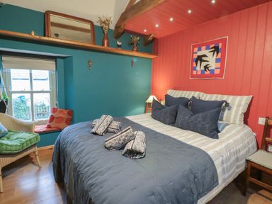 A bedroom with a bed and window at Penally Mews in St Dogmaels