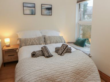 A bedroom with a bed and bedside lamp at Penally Mews in St Dogmaels