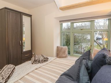 A bedroom with a bed and wardrobe at Penally Mews in St Dogmaels