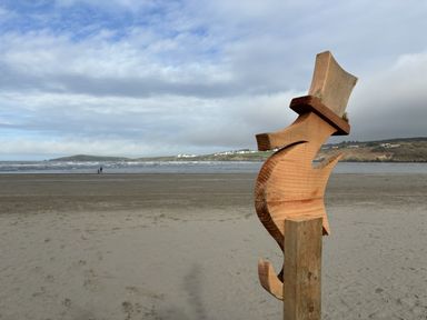 A wooden fish sculpture at the beach near the ocean at Penally Mews in St Dogmaels