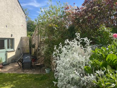 A garden with chairs and a table at Penally Mews St Dogmaels