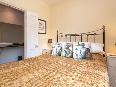 A bedroom with a bed and wall art at The Old Vicarage in St Issey