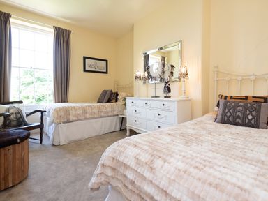 A bedroom with two beds and a dresser at The Old Vicarage St Issey