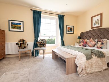 A bedroom with a bed and armchairs at The Old Vicarage in St Issey