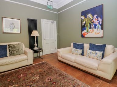 A living room with a sofa and a painting at The Boundary in Windermere