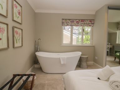 A bathroom with a bathtub and decorative wall art at The Boundary in Windermere