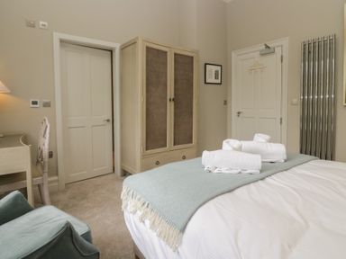 A bedroom with a bed, wardrobe, desk and chair at The Boundary in Windermere