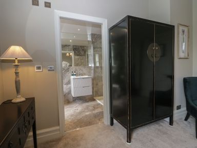 A bathroom with an open closet and a lamp at The Boundary in Windermere