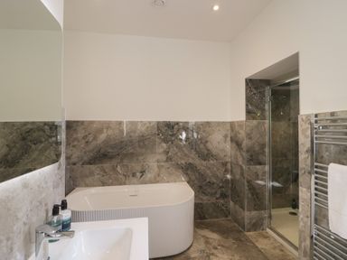 A bathroom with a shower, bathtub, and sink at The Boundary in Windermere