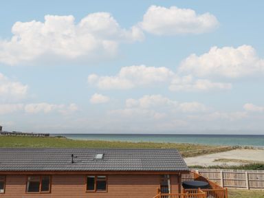 A cabin with a deck overlooking the ocean at Lodge 1 in Norwich