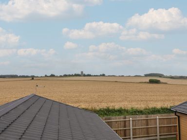A field with a distant building and a roof at Lodge 1 Norwich