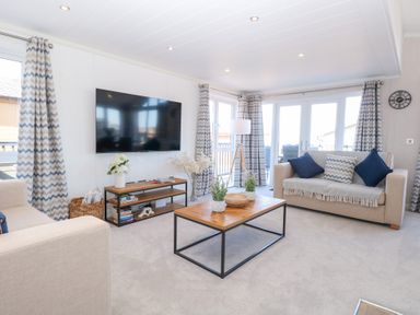 A living room with a television and coffee table at Sandy Snug in Bacton
