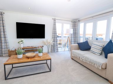 A living room with a tv and a coffee table at Sandy Snug in Bacton