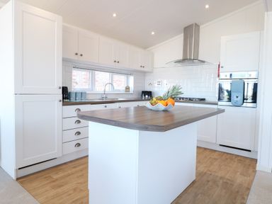 A kitchen with an island and appliances at Sandy Snug in Bacton